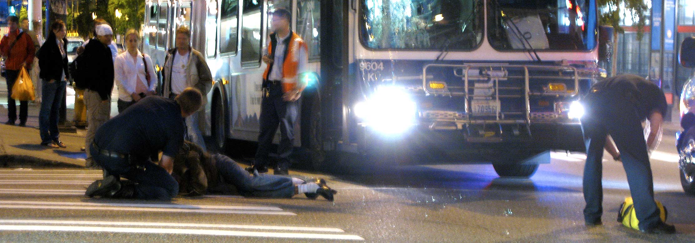 Pedestrian lies on the street after being hi by bus.